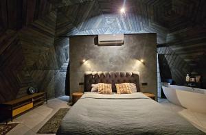 a bedroom with a bed and a tub and a sink at Trys su puse upės in Dzidai