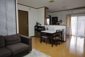 ein Wohnzimmer mit Tisch und Stühlen und eine Küche in der Unterkunft 民宿プラトーハウス in Namerikawa