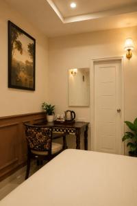 a bedroom with a desk and a table with a chair at Hotel Granton By Carlton Suites in Hyderabad