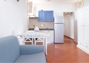 a kitchen with a table and a white refrigerator at Appartamenti Capo d'Arco in Capo D'Arco