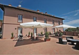 a patio with tables and umbrellas and a building at Appartamenti Capo d'Arco in Capo D'Arco