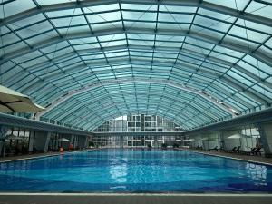 a large indoor swimming pool with a glass ceiling at Ocean Nest - 2BR Apartment in Ocean Park in Gia Lâm Pho