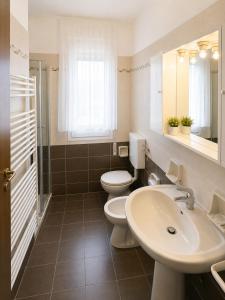 a bathroom with two toilets and a sink at Residence Caorle Apartments - Agenzia Cocal in Caorle