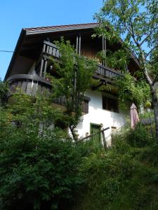 ein weißes Gebäude mit einem Balkon und Bäumen in der Unterkunft Ferienwohnungen in Schönmünzach in Baiersbronn