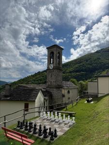 a building with a chess board and a clock tower at Rustico Indéman in Gambarogno +4 photos