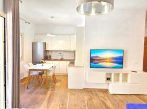 a kitchen and dining room with a tv on a wall at Sunny Beach Apartments - 147 in Durrës