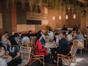 a group of people sitting at tables in a restaurant at Heirloom Guesthouse in Dimāpur