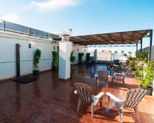 a patio with chairs and tables on a roof at Plaza de la Luz Cádiz in Cádiz