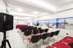 una sala conferenze con sedie rosse e schermo di Hotel Majorana a Rende