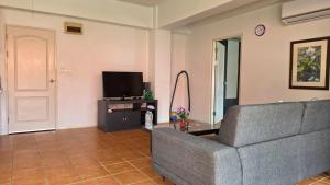 a living room with a couch and a tv at Avatara A condominium C41 with sea view in Ban Tha Fat