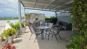 a patio with a table and chairs and plants at Avatara A condominium C41 with sea view in Ban Tha Fat
