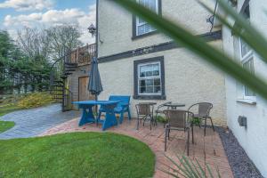 a patio with tables and chairs and an umbrella at Navitie Apartment in Ballingry