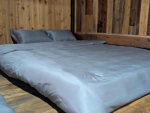 a large bed in a room with wooden walls at Mắn Mẩy homestay in Tả Van