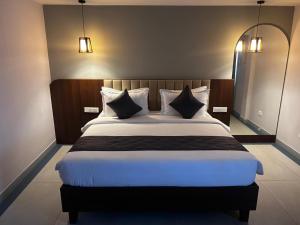 a bedroom with a large bed with black and white pillows at Casa Sevara Hotel in Vagator +73 photos
