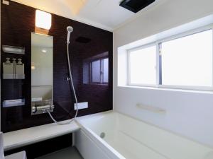 a bathroom with a bath tub and a window at Holiday Home 郷 in Minami Aso +12 photos