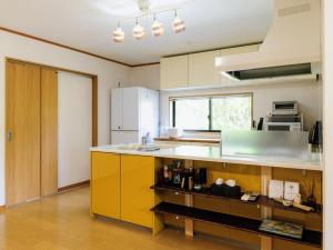 a kitchen with yellow cabinets and a counter top at Holiday Home 郷 in Minami Aso