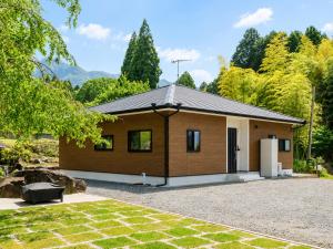 a small house with a driveway in front of it at Holiday Home 郷 in Minami Aso