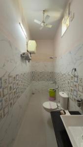 a white bathroom with a toilet and a sink at Hotel Panigrahan in Bikaner +10 photos
