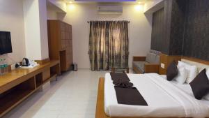 a hotel room with a large bed and a couch at Hotel Panigrahan in Bikaner