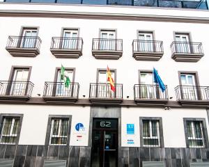 a building with three flags in front of it at Plaza de la Luz Cádiz in Cádiz