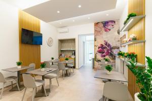 a restaurant with tables and chairs and a mural at B&B Palmares Rooms & Suites in Taviano