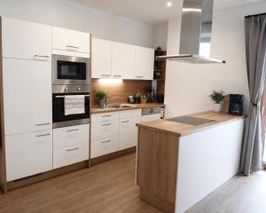 a kitchen with white cabinets and a stove top oven at Boutique Appartements Kumming inkl Nationalparkcard in Rauris