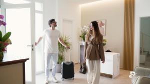 a man and a woman standing in a room with a suitcase at B&B Palmares Rooms & Suites in Taviano +101 photos