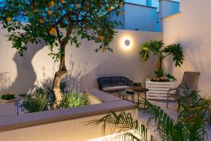 an indoor garden with an orange tree and chairs at B&B Palmares Rooms & Suites in Taviano