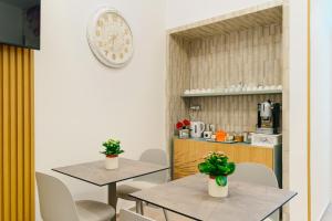 a kitchen with two tables and chairs with plants on them at B&B Palmares Rooms & Suites in Taviano