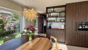 a dining room with a table with a vase of flowers at House W - North Sea Stays in De Haan