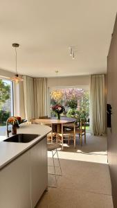 a kitchen and dining room with a table and a table at House W - North Sea Stays in De Haan