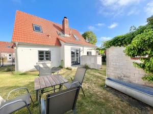 a table and chairs in the yard of a house at Kachelofenhaus in Fehmarn