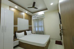 a small room with a bed and a ceiling fan at Hotel Welcome inn in Patna