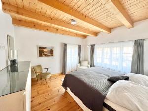 a bedroom with a large bed and a wooden ceiling at Kachelofenhaus in Fehmarn