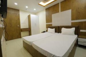 a bedroom with a large white bed and a television at Hotel Welcome inn in Patna
