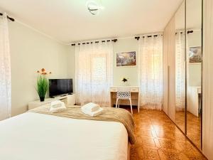 a white bedroom with a bed and a desk at Casa di Mary in Châtillon