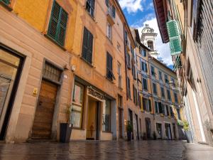 a city street with buildings and a clock tower at Nel centro storico di Ovada in Ovada