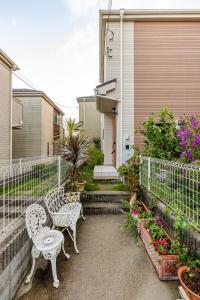 a patio with two chairs and flowers in front of a house at Sea Breeze 三浦 in Miura