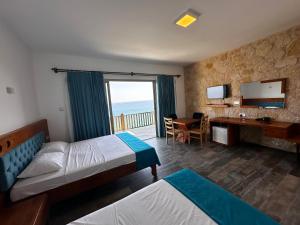 a hotel room with two beds and a desk at Golden Hill Hotel in Rizokarpaso