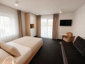 a hotel room with a bed and a couch at Villa Viola in Mielno