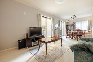 a living room with a tv and a table at Sea Breeze 三浦 in Miura