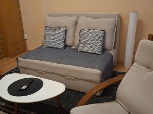 a bed with pillows and a table and a chair at M&O Belgrade in Belgrade