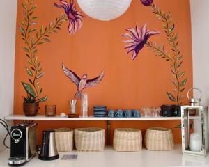a shelf with a bird on an orange wall at L'Effet Papillon - Maison d'hôtes in Sauges +20 photos