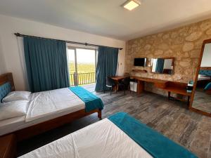 a hotel room with two beds and a desk at Golden Hill Hotel in Rizokarpaso