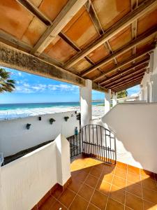 a balcony with a view of the beach from a house at Hostal Rios in Bolonia