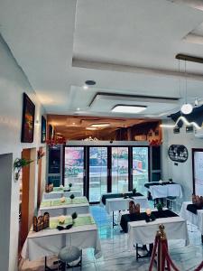 a restaurant with white tables and chairs and windows at Akrafthaus by KAVKANZ in Abuja