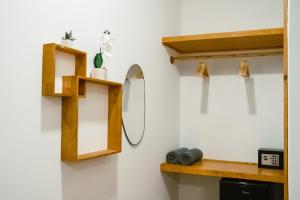a bathroom with wooden shelves and a mirror at Oasis Retreat Dhiffushi in Dhiffushi