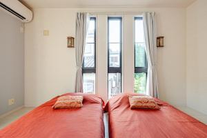 two beds in a room with a large window at Sea Breeze 三浦 in Miura