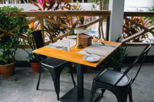 a wooden table and two chairs and a table and chairs sidx sidx sidx at Oasis Retreat Dhiffushi in Dhiffushi