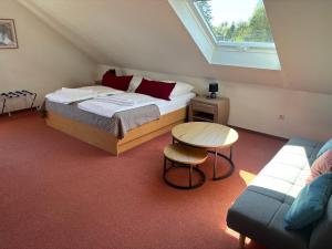a bedroom with a bed and a table and a window at Hotel Friesenhof in Westoverledingen